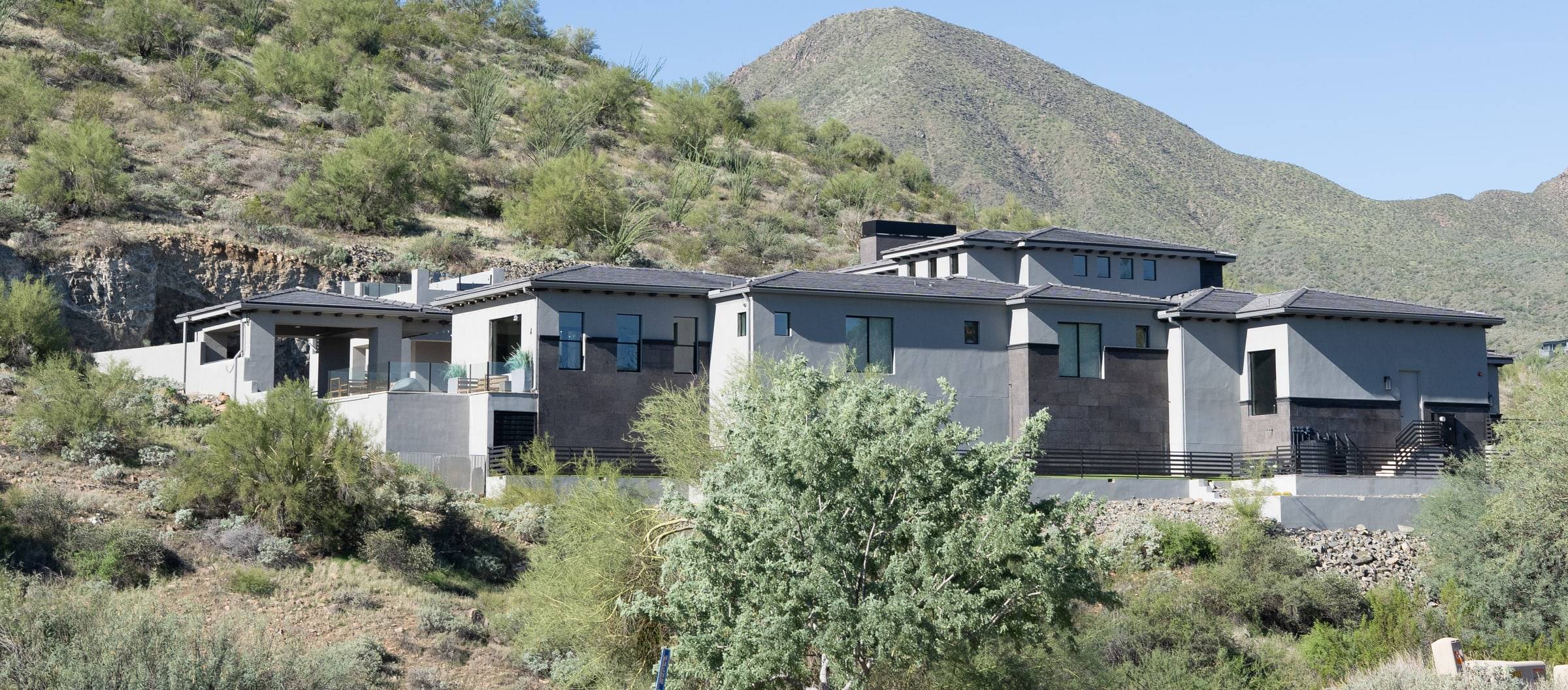 Modern custom homes on a hillside with a mountain backdrop — Echelon Fine Home Builders